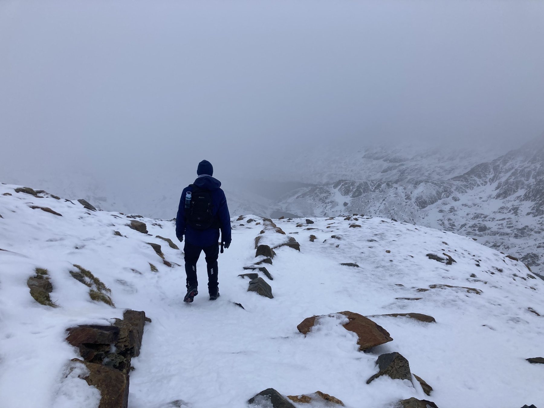 Marcos caminhando numa trilha com neve e neblina